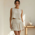 Woman wearing a beige linen set with skirt in a bright room