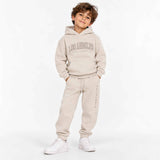 Boy wearing a beige Los Angeles hoodie and matching joggers with white sneakers