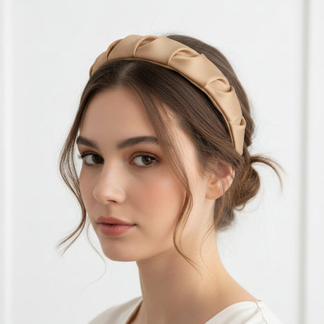 Beige padded headband styled with a low bun and loose face framing strands