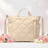 Beige quilted handbag with flowers on a soft pink background