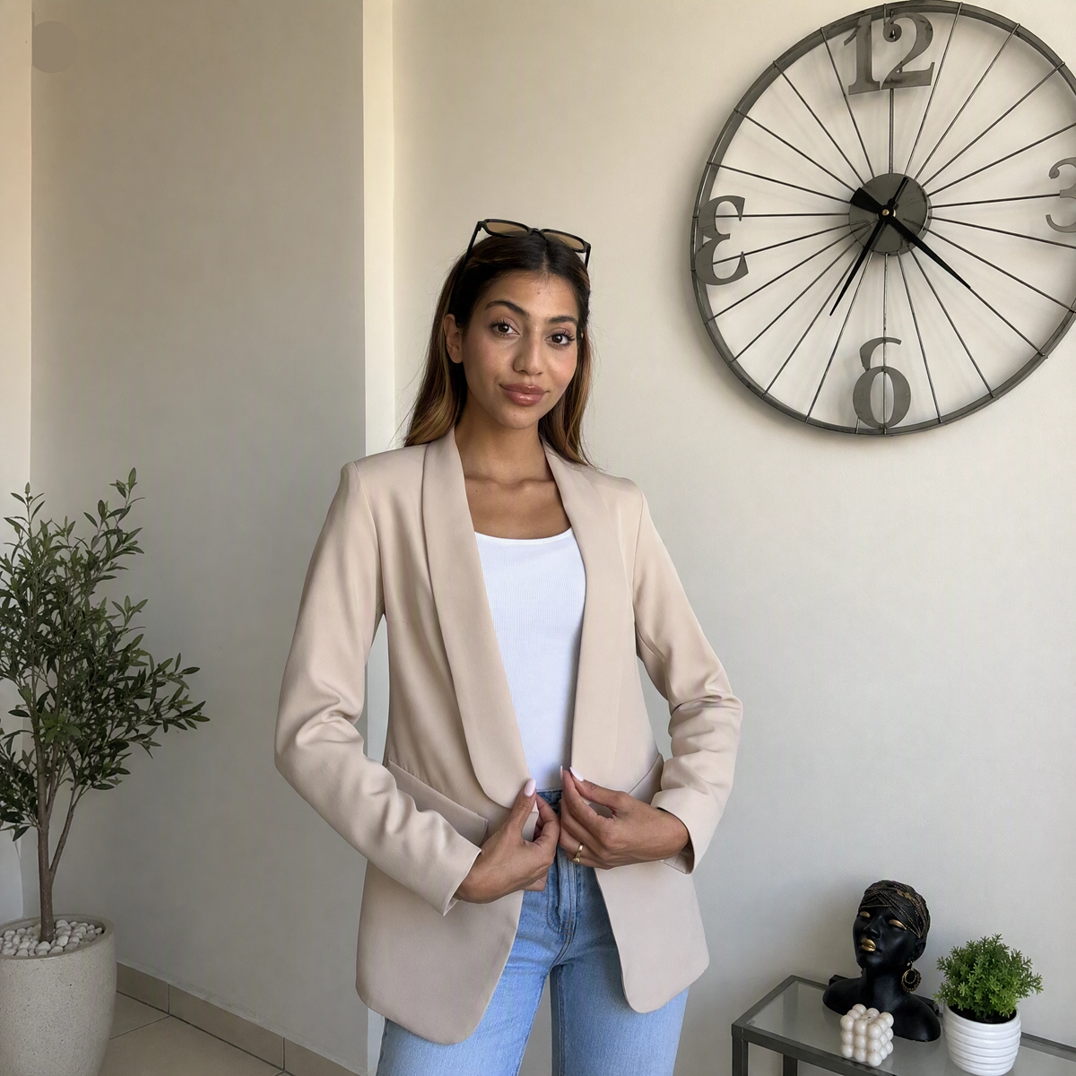 Beige blazer held closed at the front, showing the drape of the open lapel
