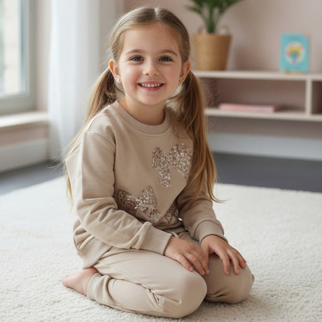 Girl in a beige sequin bow sweatshirt and matching cuffed joggers