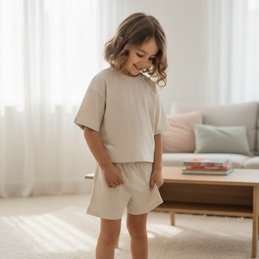 Girl in a beige speckled tee and matching shorts set indoors