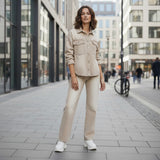 Woman in beige outfit standing on a city street