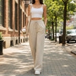 Beige wide leg sweatpants worn on a pavement with a white top