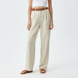 Person wearing beige wide-leg pants with a brown belt on a white background