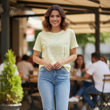 Pastel yellow tee with a Believe in Yourself script worn with blue jeans at a cafe