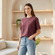 Woman wearing a maroon tshirt with white patterns in a modern living room