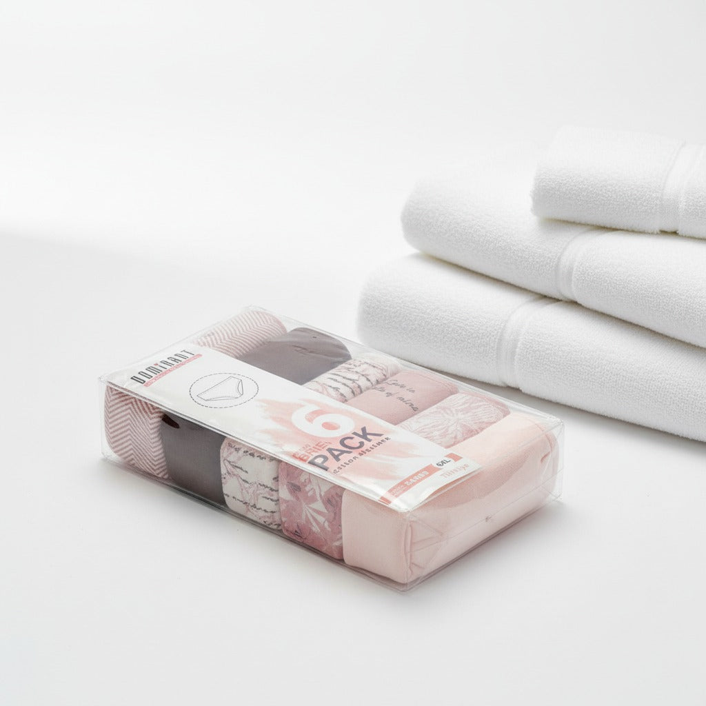 Sealed six pack of neutral tone briefs beside folded white towels