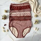 Stack of burgundy briefs with paisley and floral prints on white marble