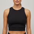 Woman wearing a black athletic top against a plain background