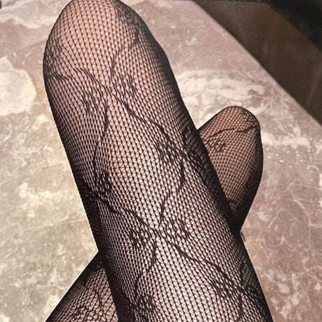 Black bow print fishnet stockings on a textured surface