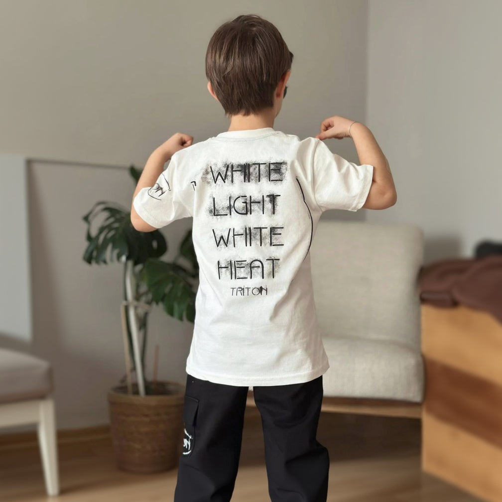 Back of a boys cream tee with a black slogan print worn with black cargo joggers