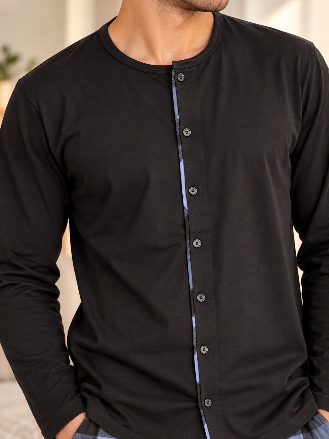 Close up of the black pyjama top with a full button placket and blue check trim