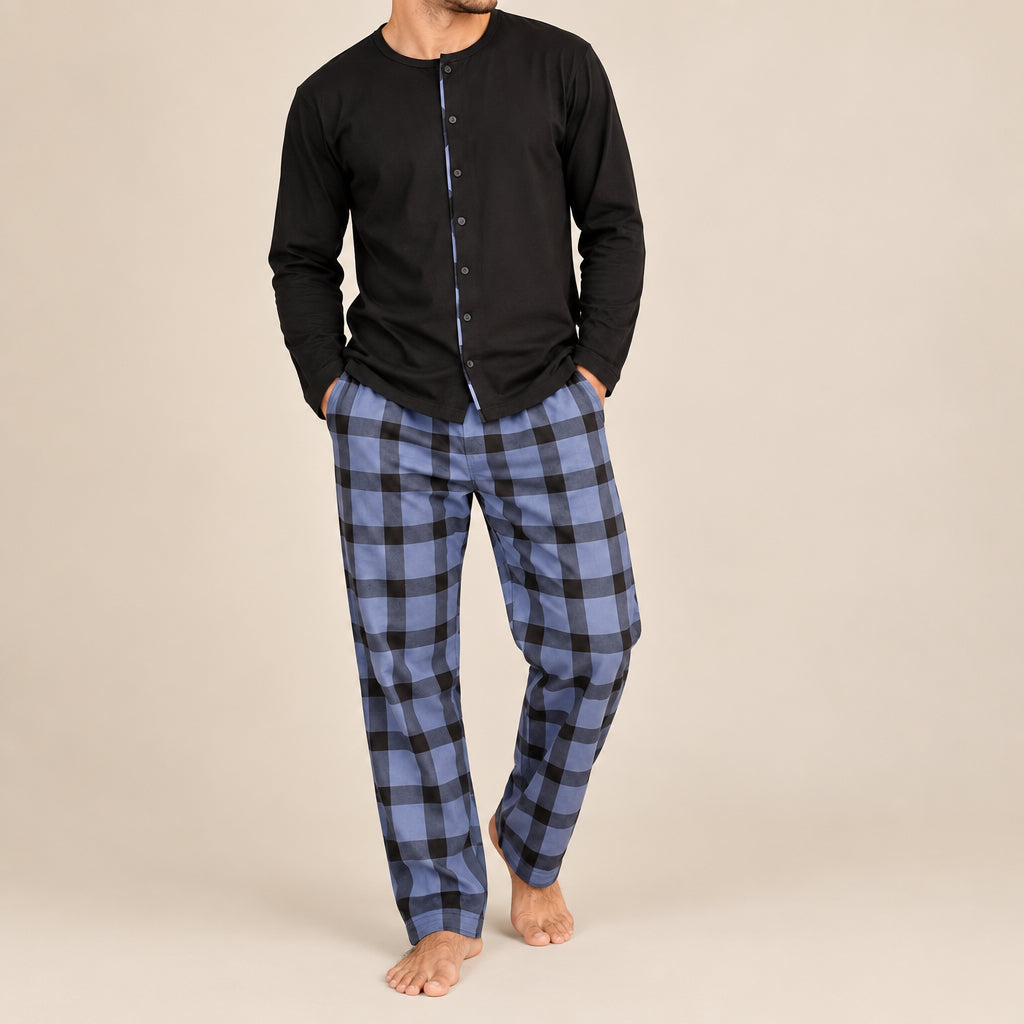 Front view of a man standing in a black pyjama top and blue buffalo check trousers
