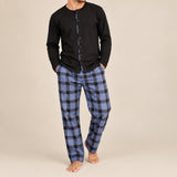 Front view of a man standing in a black pyjama top and blue buffalo check trousers