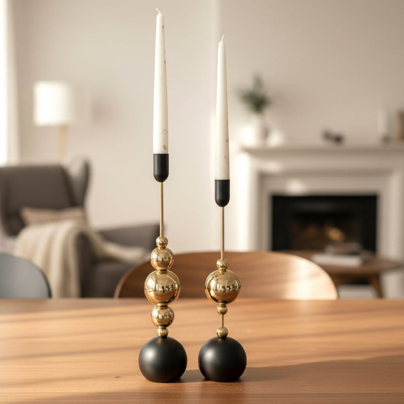 The black and gold pair on a wooden table in front of a lit open fireplace