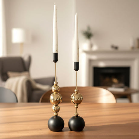 The black and gold pair on a wooden table in front of a lit open fireplace