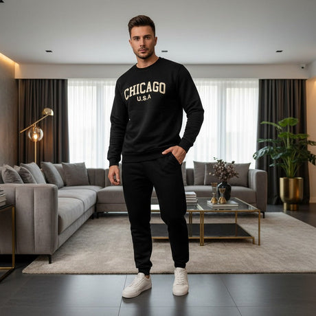 Man wearing a black 'Chicago' sweatshirt and pants in a modern living room