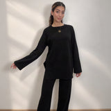 Black knit crew neck sweater with side slits and matching wide leg trousers