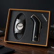 Glossy black curved cigar lighter and gunmetal oval cigar cutter in a gold edged gift box