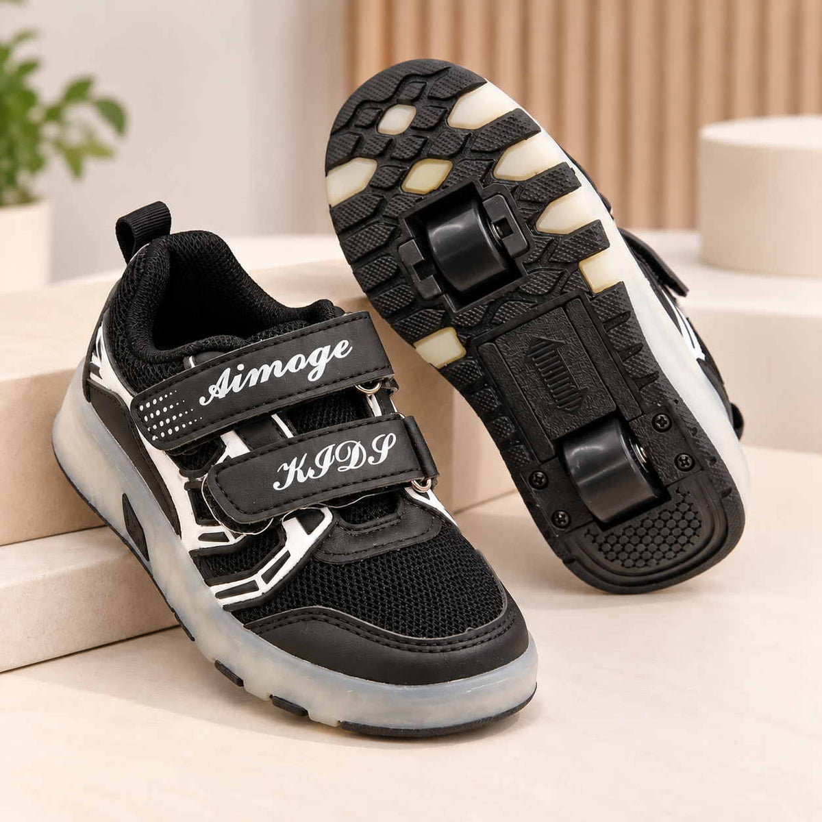 Black roller shoes shown as a pair, one turned over to show the two wheels set into the sole
