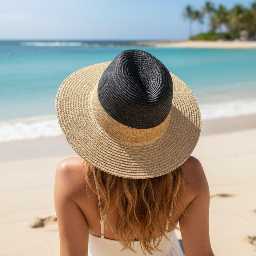 Two tone straw hat viewed from above, black weave crown meeting a pale flat brim