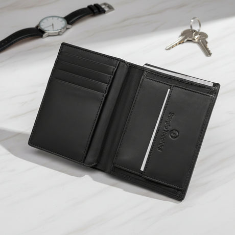 Black leather wallet with a brand logo opened on a light surface, accompanied by a watch and keys