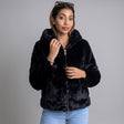 Black plush faux fur hooded jacket with a gold zip worn open over light blue jeans