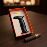 Cigar lighter in a branded box on a wooden surface with a cigar beside it