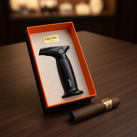 Cigar lighter in a branded box on a wooden surface with a cigar beside it