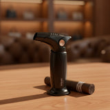 Black butane lighter and a cigar on a wooden table with a blurred background