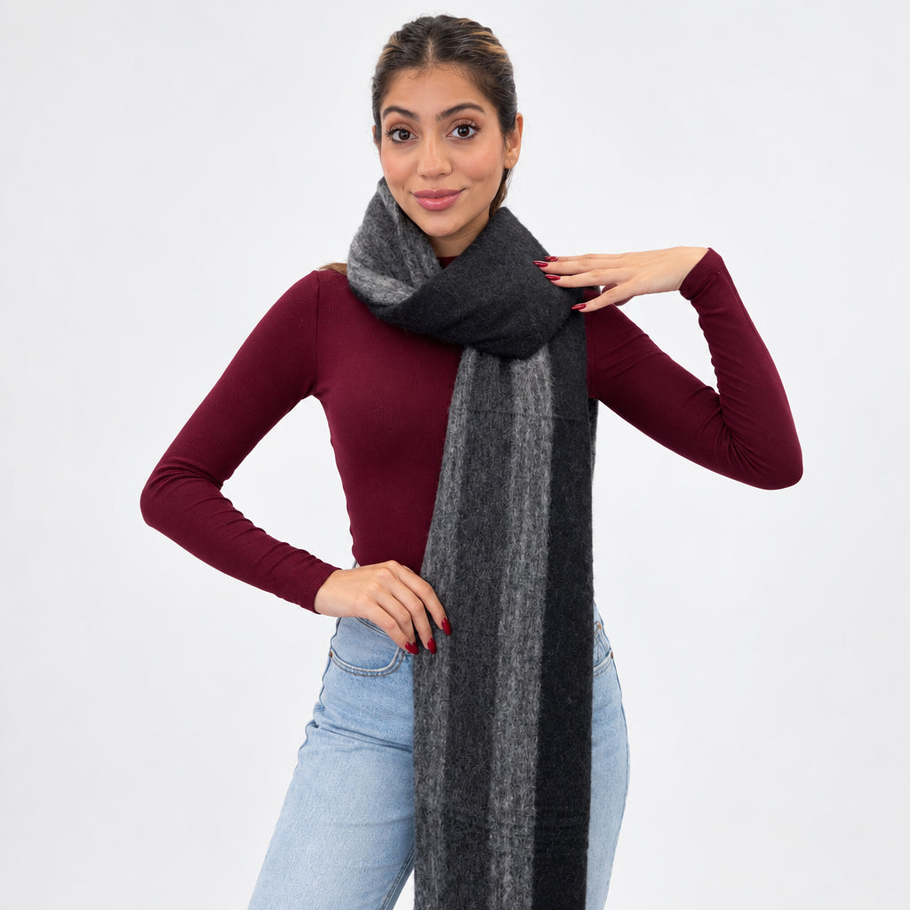 Woman in a burgundy top and jeans wearing a long black brushed scarf with a charcoal grey stripe