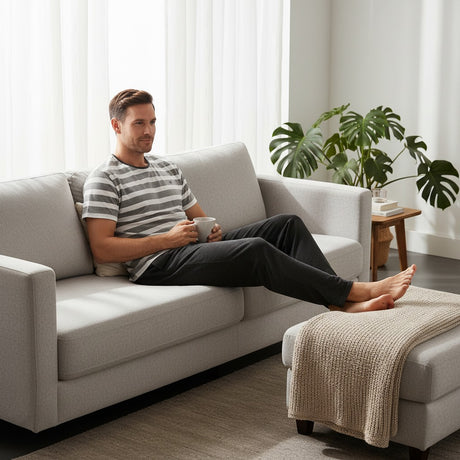 Black heather pyjama set worn relaxing on a sofa with feet up