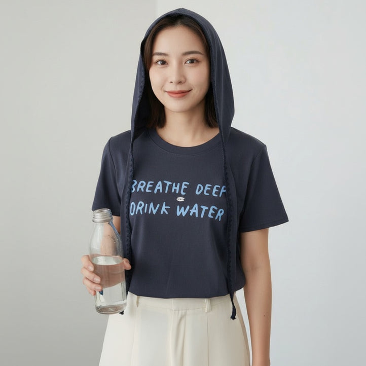 Person wearing a black tshirt with 'Breathe Deep Drink Water' text, holding a water bottle