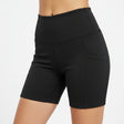Woman wearing black athletic biker shorts against a white background