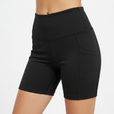 Woman wearing black athletic biker shorts against a white background