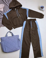 Black hoodie and sweatpants with blue accents on a light surface