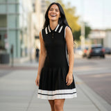 Woman wearing a black dress with white accents on a city street