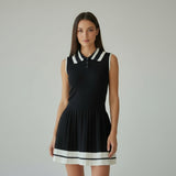 Woman wearing a black dress with white trim on a grey background