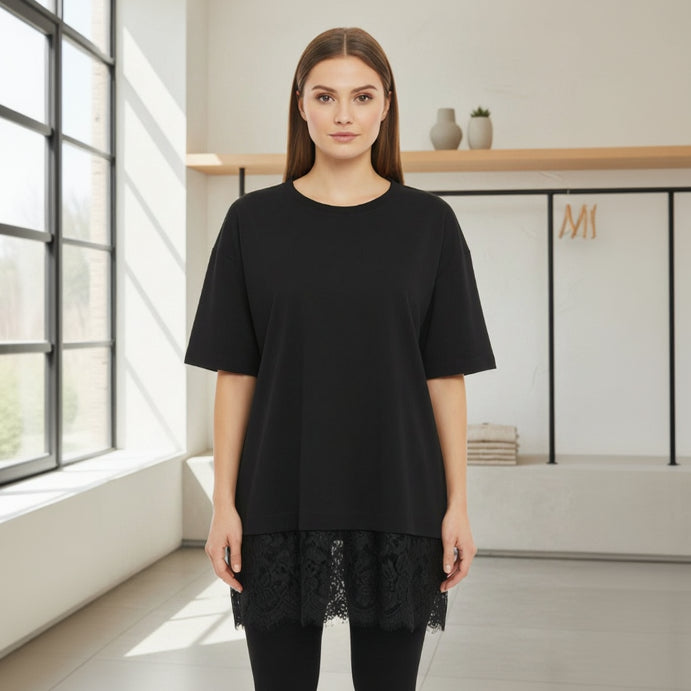 Woman wearing a black top with lace details in a bright room