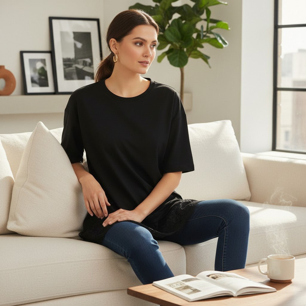 Woman wearing a black lace tshirt sitting on a couch in a living room