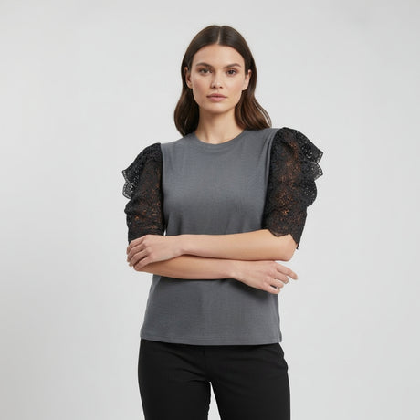 Woman wearing a gray top with black lace sleeves on a white background