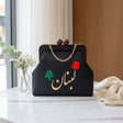 Black Lebanon frame bag styled on marble beside a vase of eucalyptus