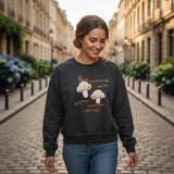 Close view of oatmeal mushroom embroidery and orange script on black fleece
