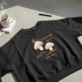 Black mushroom sweatshirt styled with blue jeans on a cobbled street