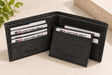 Black nubuck bifold wallet open with a slim matching card holder resting inside