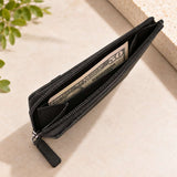 Unzipped black card wallet revealing folded banknotes inside its leather lined pocket