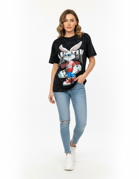 Woman wearing a black tshirt with a graphic bunny design and light blue jeans on a white background