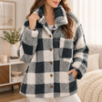 Woman in a black and white plaid sherpa jacket with one hand in a side pocket